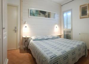 阿兰奇湾城B&B Casa Derosas的卧室配有一张带白色棉被的床和窗户。