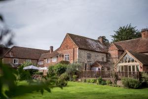 une ancienne maison en briques avec une pelouse devant elle dans l'établissement Howfield Manor Hotel, à Canterbury