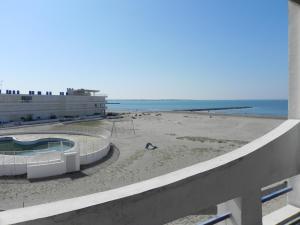 uma vista para a praia a partir da varanda de um edifício em RESIDENCE DE LA MER em Le Grau-du-Roi