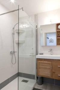 uma casa de banho com uma cabina de duche em vidro e um lavatório. em RESIDENCE DE LA MER em Le Grau-du-Roi