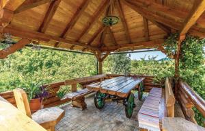 a wooden patio with a wooden table and benches at Holiday home/apartments Vaska in Moravice