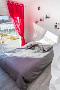 sypialnia z łóżkiem z czerwoną zasłoną w obiekcie Chambre d'hôtes source de la St Baume w mieście Plan dʼAups
