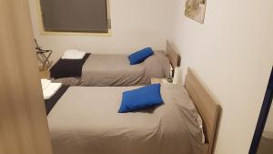 two beds in a room with a white bedspread at Etna Parking in Catania
