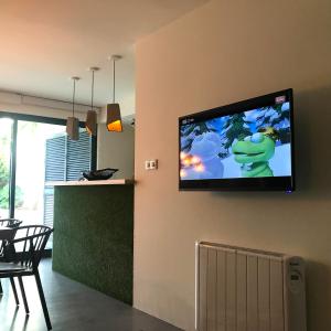 een flatscreen-tv aan de muur van een woonkamer bij LUZZ me - Casa de Angra in Angra do Heroísmo