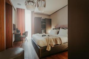 a bedroom with a large bed and a chair at Bacã Suites, Restaurant & Bar in Taranto