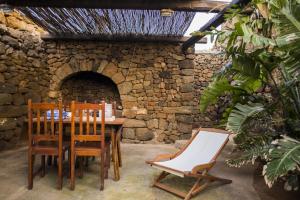 a table and chairs in front of a stone oven at Dammuso Sant'Anna in Pantelleria