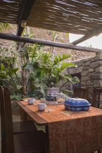 une table avec deux tasses et une plaque bleue sur elle dans l'établissement Dammuso Sant'Anna, à Pantelleria