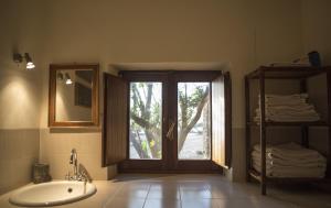 a bathroom with a tub and a sink and a window at Dammuso Sant'Anna in Pantelleria