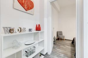 a white hallway with white shelves and a chair at The Miki House in Rome