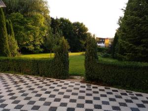 un pavimento a scacchi in un giardino con alberi e erba di Ferienapartment Tuntenhausen a Tuntenhausen