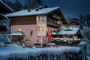 una casa grande en la nieve con nieve en Landgasthof Neuwirt, en Lofer