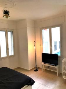 1 dormitorio con 1 cama y TV de pantalla plana en 38 Rue Papety, en Marsella