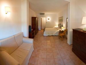 a living room with a couch and a bed at Hotel Spartivento in Chia