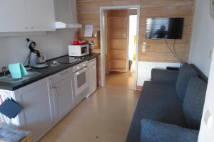eine kleine Küche mit einer Theke und einer Couch in einem Zimmer in der Unterkunft Welcome House in Wendlingen am Neckar