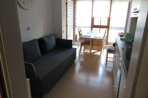 ein Wohnzimmer mit einem blauen Sofa und einem Tisch in der Unterkunft Welcome House in Wendlingen am Neckar