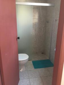 um banheiro com vaso sanitário e chuveiro em Pousada Bertioga em Bertioga mais 25 fotografias