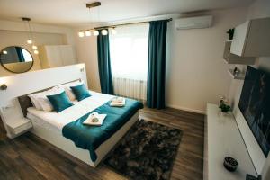 1 dormitorio con cama con almohadas azules y espejo en Briana Luxury Apartment en Cluj-Napoca