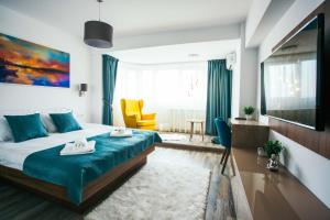 a bedroom with a bed with blue sheets and a yellow chair at Briana Luxury Apartment in Cluj-Napoca +12 photos