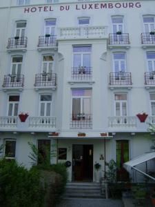 un bâtiment blanc avec balcon et un hôtel durlezlez dans l'établissement Hotel Luxembourg, à Lourdes