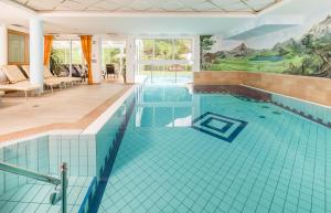 uma piscina com azulejos azuis numa casa em Vitalpina Hotel Magdalenahof em Santa Maddalena in Casies