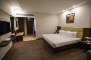 pokój hotelowy z łóżkiem i telewizorem w obiekcie Jaag Hotel w mieście Ćennaj