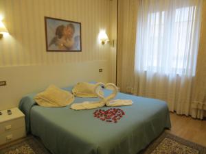 a hotel room with a bed with a ribbon on it at Hotel Italia City Center in Mantova