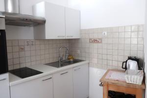 a kitchen with white cabinets and a sink and a table at Apartment Maya in Kranjska Gora