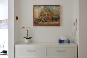 a painting above a white dresser in a room at Apartment Maya in Kranjska Gora