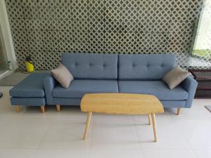 a blue couch in a living room with a table at Minh Kim Guesthouse in Ấp Phó