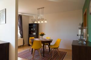 a dining room with a table and yellow chairs at Apartement 1 Große Brüdergasse in Bautzen