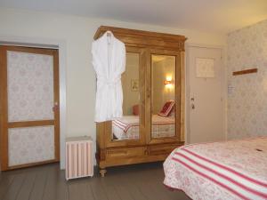 a bedroom with a bed and a dress hanging up at Guesthouse Alizée in Leuven