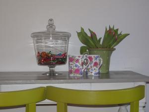 stół ze szklanym słoikiem i doniczką w obiekcie Guesthouse Alizée w mieście Leuven