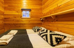 ein Schlafzimmer mit einem Bett in einer Holzhütte in der Unterkunft Kuukkeli Apartments Tokka in Saariselkä