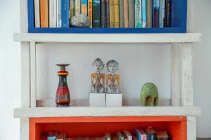 a book shelf with books and figurines on it at Amanta Beach in Nilaveli