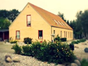 una casa con techo y jardín enfrente en Molevitten Apartments, en Søby