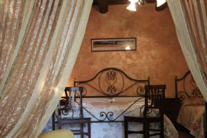 a bedroom with a bed and chairs in a room at Agriturismo Il Capannone in Montemerano