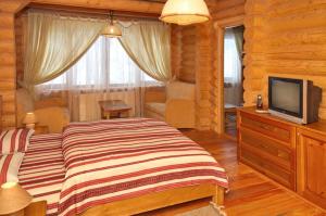 Un dormitorio con una cama grande y un televisor. en Marika, en Dragobrat
