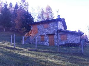 Le Bratte的住宿－Agriturismo I Conti Di Piscè，一座小石头建筑,在田野上设有楼梯