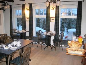 a dining room with tables and chairs and windows at B&B Fiddler's Inn in Neuruppin