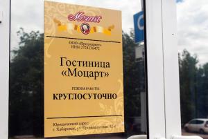 a sign for a restaurant in a window at Mozart Hotel in Khabarovsk