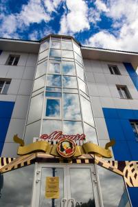 a building with a sign on the front of it at Mozart Hotel in Khabarovsk