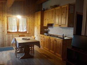 a kitchen with wooden cabinets and a table and a television at Agriturismo I Conti Di Piscè in Le Bratte
