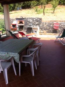een patio met een tafel en stoelen en een open haard bij Le Ginestre in Levanto