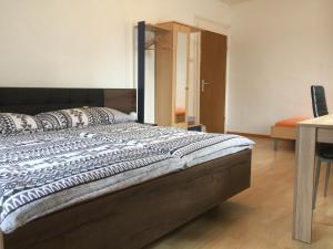 a large bed in a room with a table and a desk at Walters Hostel Interlaken in Interlaken