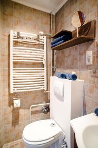 een kleine badkamer met een witte koelkast en een wastafel bij Indigo Apartment With Free Parking in Boedapest