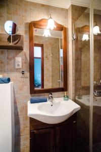 een badkamer met een wastafel en een spiegel en een douche bij Indigo Apartment With Free Parking in Boedapest +15 foto's