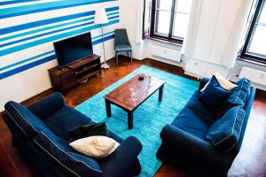 ブダペストにあるIndigo Apartment With Free Parkingのリビングルーム(青いソファ2台、コーヒーテーブル付)