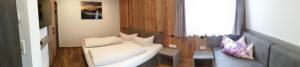 ein kleines Zimmer mit einer weißen Couch und einem Stuhl in der Unterkunft Apartment Wandspitz in Hintertux