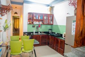 a kitchen with green chairs and a counter at Kota's House Homestay in Hue