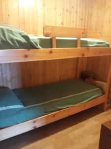 Litera en habitación con paredes de madera en Agriturismo I Conti Di Piscè, en Le Bratte